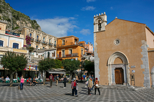 Taormina, Sicily, Italy - november 13, 2019: tourist on IX Aprile plaza, central square of the old town in Taormina. Taormina is one of the most beautiful and popular towns in Sicily.\