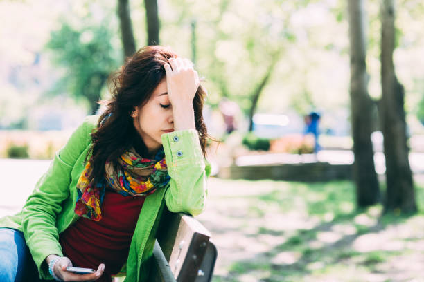 istock Young woman feeling depressed in the park 1200129743