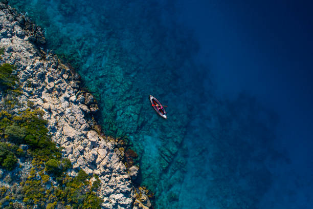 Woman kayaking clear turquoise sea