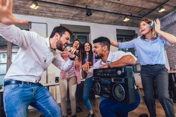 istock Business people making team training exercise during team building seminar singing karaoke. 1200132726
