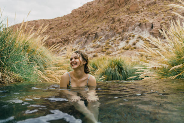 Woman in hot spring in Atacama desert Young Caucasian woman swimming  in hot spring in Atacama desert chile tourist stock pictures, royalty-free photos & images