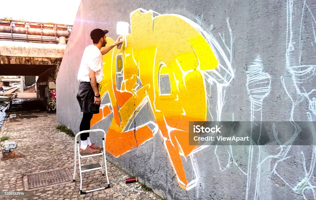  Artista Callejero Que Trabaja En Grafitis De Colores En La Pared Del Espacio Público Arte Moderno Realizar Concepto De Chico Urbano Pintar Murales En Vivo Con Aerosol Aerosol Amarillo Y Naranja Spray