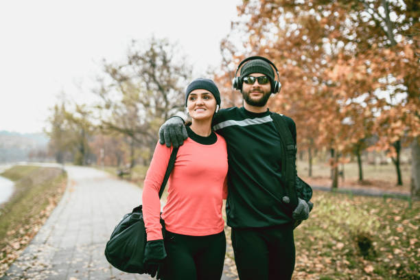 Athletic Couple Embracing After Training Session In Park