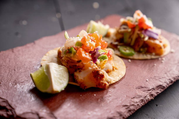 Mexican Style Fish Street Food Tacos on a Rustic Slate Ready to Eat Mexican Style Fish Street Food Tacos on a Rustic Slate Ready to Eat mexican culture food mexican cuisine fajita stock pictures, royalty-free photos & images