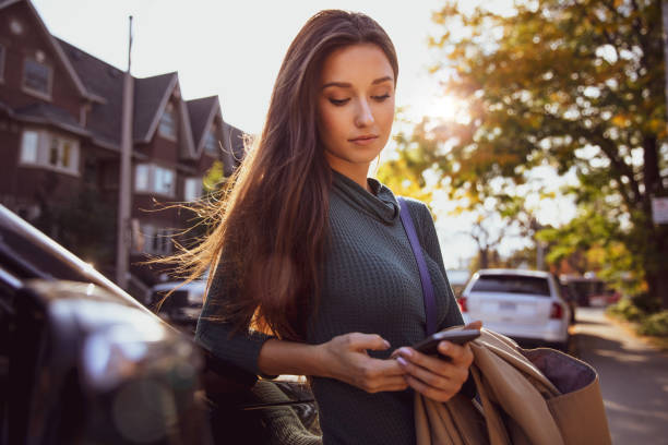 istock Woman texting right out of her car 1200137764