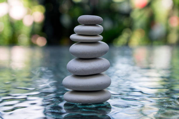 istock Stone cairn on green blurry background, light pebbles and stones 1200139226