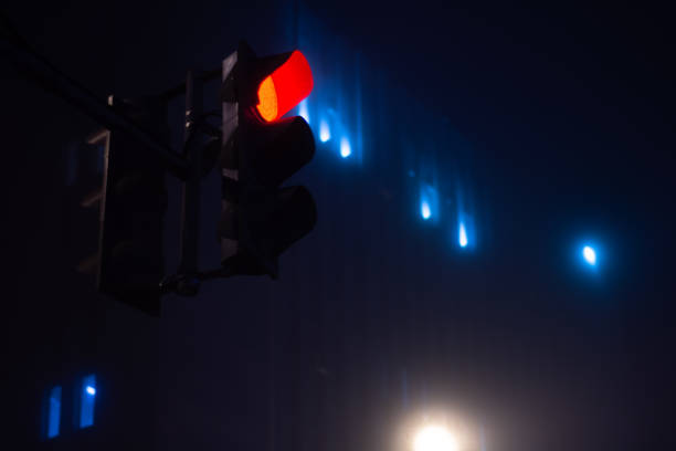 istock Red traffic light at night during foggy weather 1200139252