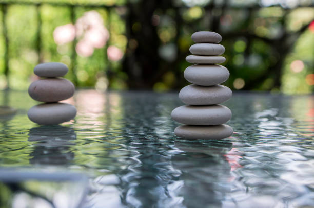 istock Stone cairn on green blurry background, light pebbles and stones 1200139310