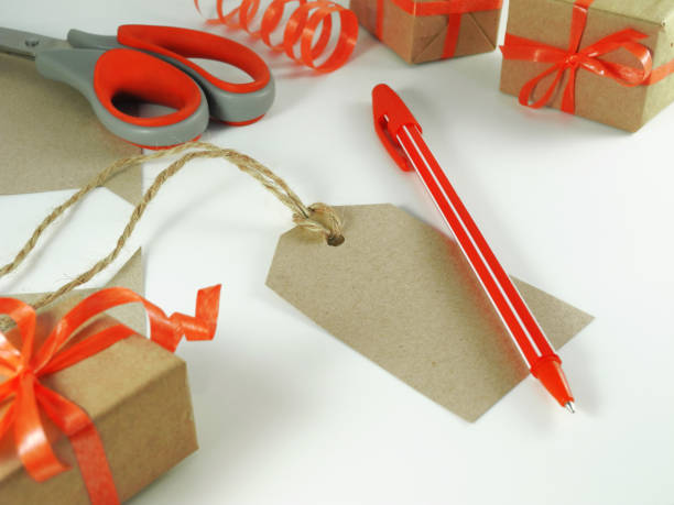 istock Handmade gift tag with red handle surrounded of wrapped gift boxes. 1200142072