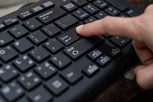 close up botão de pressão do dedo indicador digite no teclado do computador - enter key - fotografias e filmes do acervo