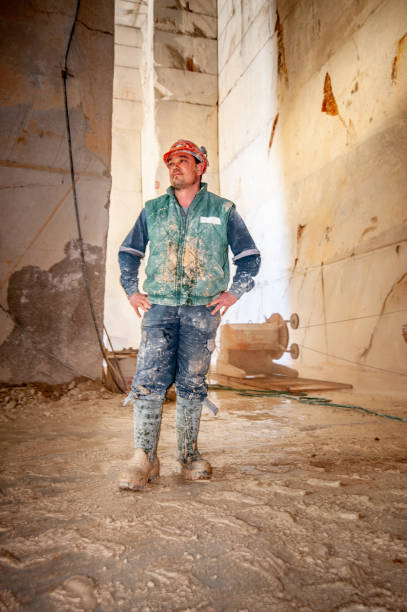 Dirty Quarry Worker Standing in Underground Corridor.