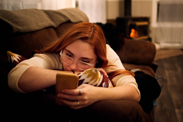istock Young woman relaxing on a couch with smart phone. 1200143243