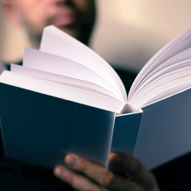istock Men's hands hold a white book with clean pages 1200143814