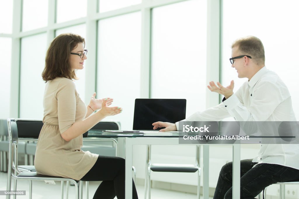 Discuss Work Two Employees Discuss Work Issues At The Office Desk Stock Photo ...