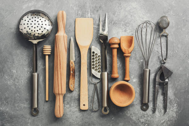 istock Flat lay kitchen tools and utensils on a gray concrete background, toned. Top view. Kitchenware is metal and wood. 1200148490