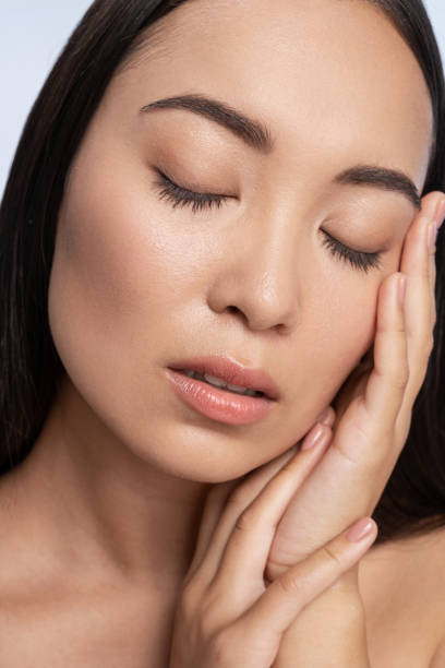 istock Attractive Asian woman posing for camera in studio 1200148494