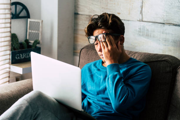 étudiant stressé à la maison étudiant avec l'ordinateur portable personnel - adolescent fatigué pour le travail d'école -internet. dépendance pour le jeu ou le concept de recherche d'emploi - activité de technologie intérieure - using laptop laptop teenager student photos et images de collection