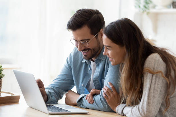 istock Happy young mixed race couple watching funny videos on computer. 1200153055