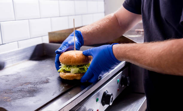 istock Chef preparing burgers at the kitchen grill stove. Restaurant. 1200154135