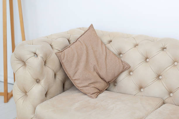istock Textured interior sofas and neutral tones. Pillow on the sofa in the room. Brown pillow on a stylish sofa in the living room. Home decor, interior details. Scandinavian style home. Room design 1200154367