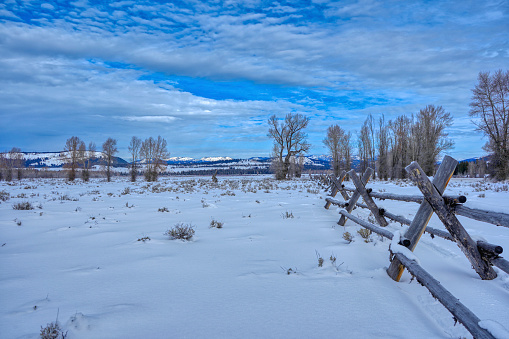 Wooden fence in the winter at Christmas time in the Grand Tetons National Park and Yellowstone National Park area. As the snow forms a thick blanket across the Tetons Range, wildlife becomes more visible and the scenery more dramatic than then the busy summer season.