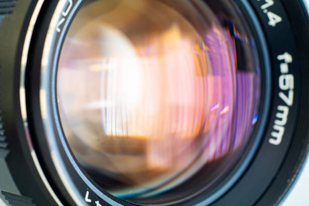 古いヴィンテージ高速開口プライムレンズフロント要素クローズアップは、カラフルなコーティング反射を示しています - lighting technique aperture lens color image ストックフォトと画像