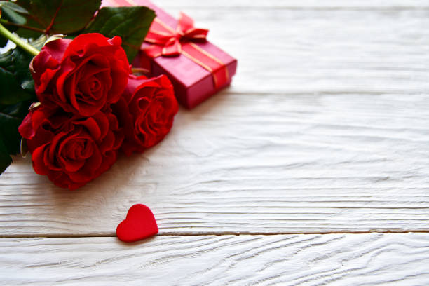 istock Tree red roses and gift box on a white wooden background. St. Valentine's Day background. 1200156628