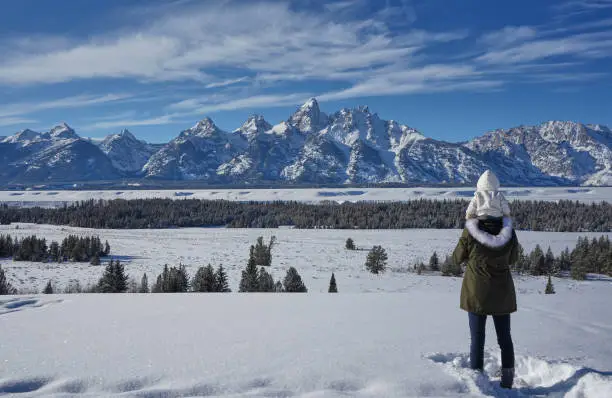 Mother and daughter in the winter at Christmas time in the Grand Tetons National Park and Yellowstone National Park area. As the snow forms a thick blanket across the Tetons Range, wildlife becomes more visible and the scenery more dramatic than then the busy summer season.