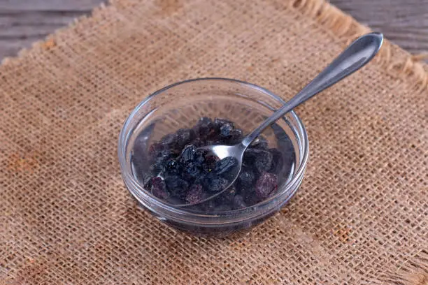 Dried raisins in a bowl are prepared for baking. Cooking porridge