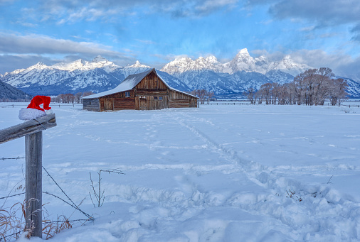 Abandoned Moulton Barn on Mormon Row in the winter at Christmas time in the Grand Tetons National Park and Yellowstone National Park area. As the snow forms a thick blanket across the Tetons Range, wildlife becomes more visible and the scenery more dramatic than then the busy summer season.
