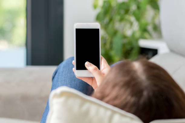istock Woman using and showing a blank phone screen 1200158680