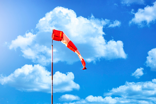 Wind sign against a cloudy blue sky