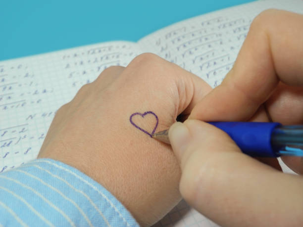 istock Hand with pen draws heart on skin. 1200160772