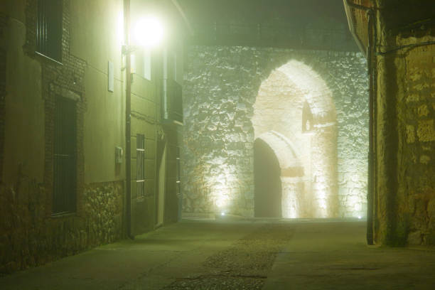 istock Street with a wall gate a foggy night 1200166491