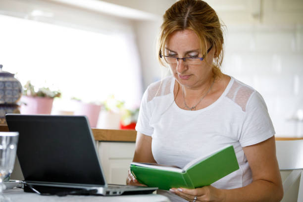 Middle-aged woman using laptop at home