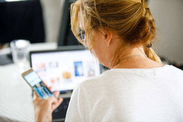 istock Middle-aged woman using laptop at home 1200167103