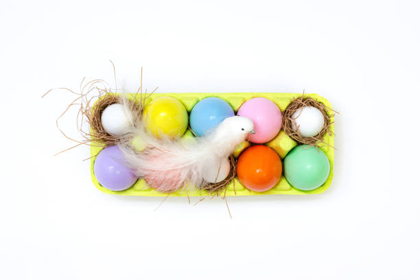 Top view of an Easter composition of painted eggs in bright juicy colors with a glossy texture that lie in the container and a white bird sits on top. Holiday concept, flat layout, easter, background vista superior de una composición de pascua de huevos pintados en colores jugosos brillantes con una textura brillante que se encuentran en el recipiente y un pájaro blanco se sienta en la parte superior. concepto de vacaciones, diseño plano, pascua, fo