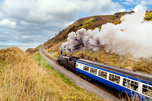 Steam train with passenger carriages on costal railway
