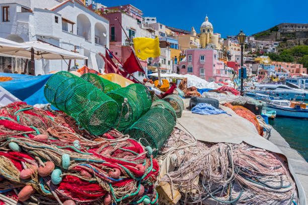 Pretty fishing village, colourful fishermen's houses, and fishing nets, Marina Corricella Procida Island, Bay of Naples, Italy. stock photo