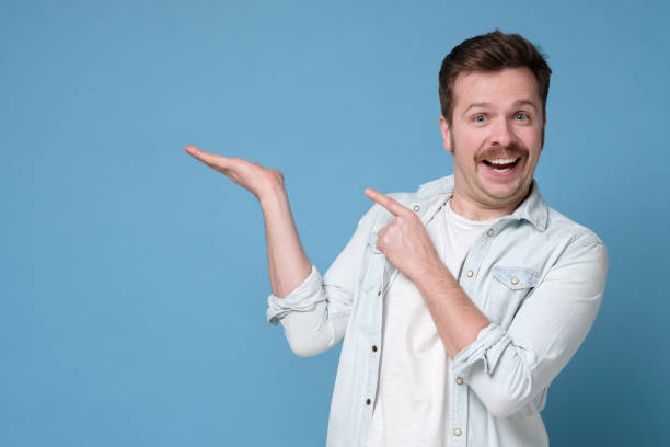 istock Man with mustache show empty copy space on open palm gesture for your ad, demonstrate advertise product 1200171185