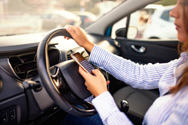 istock Closeup inside vehicle of hand holding smartphone 1200172002
