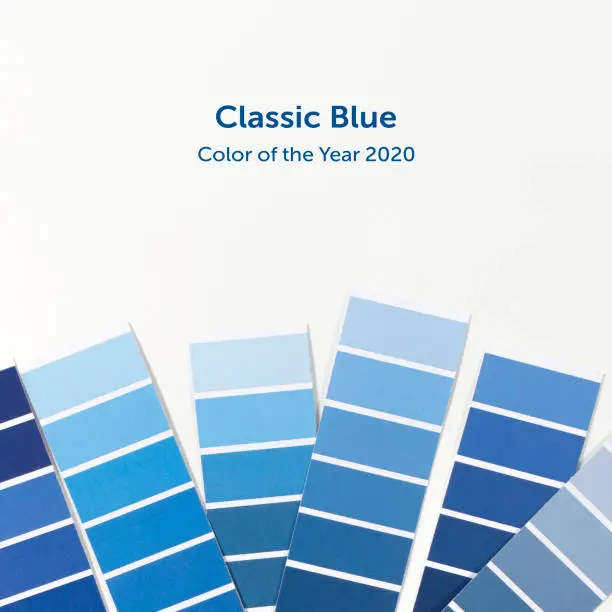 Photo of Color swatches with color of the year 2020 in the hand - Classic Blue. Color trend palette. Top view, flat lay.