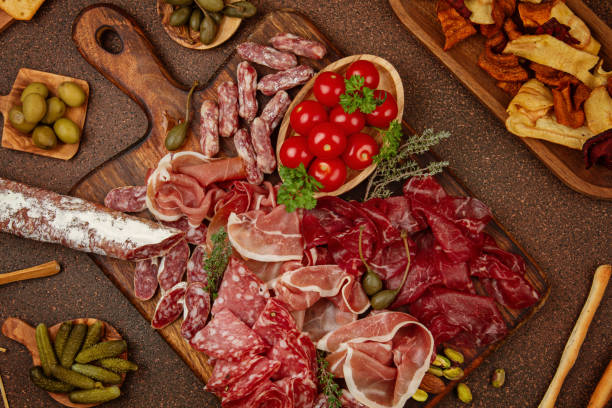 istock Appetizers table with differents antipasti, cheese, charcuterie, snacks and wine. Sausage, ham, tapas, olives, cheese and crackers for buffet party. 1200175711