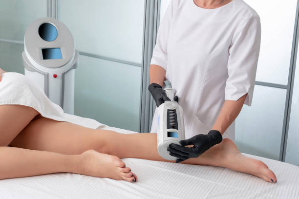 istock cosmetologist in rubber gloves doing Microvibration Therapy on female legs 1200181717