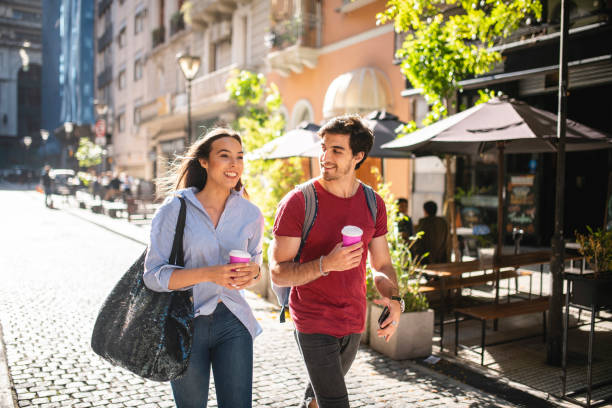 Vacationing Couple Walking with Coffee and Smart Phone