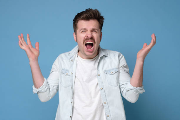 istock Young caucasian man with mustache indignantly gesticulates with his hands and looks at camera. 1200183437
