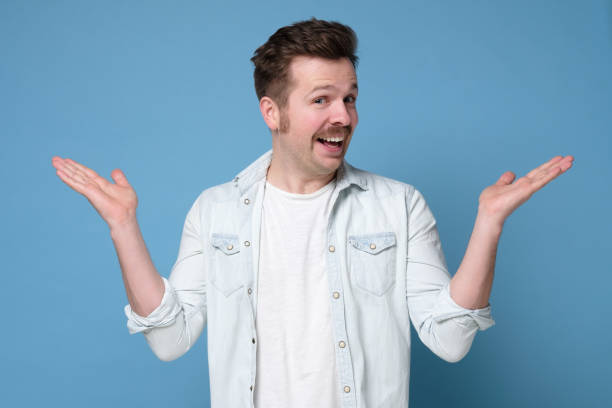 istock Excited casual man with mustache standing with raised hands and looking at camera being happy. 1200185536