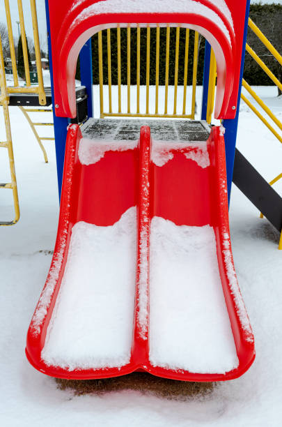 istock Red slide empty residential playground in the snow 1200190300