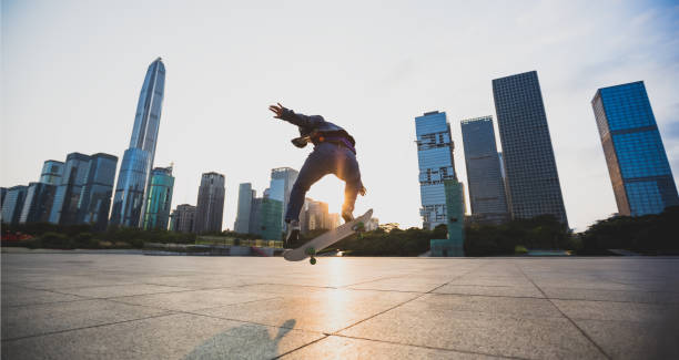 istock Skateboarder skateboarding at sunset city 1200192111