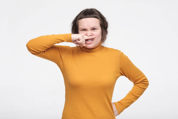 istock Female student squeezing nose with fingers, looking in camera with disgust, feeling bad smell outside. 1200193138